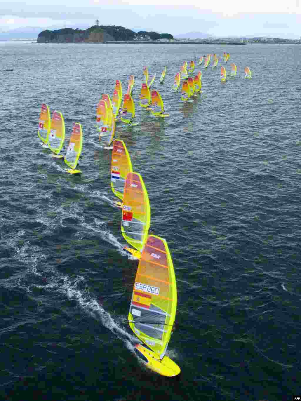 An aerial view shows competitors taking part in the men&#39;s RS:X class windsurfing event as part of the sailing World Cup series, a test event ahead of the upcoming Tokyo 2020 Olympic Games, in the waters off Enoshima island.