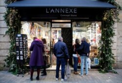 People line up outside a shop in Bayonne, southwestern France, Nov. 28, 2020. Non-essential shops around France are opening their doors as part of a staggered relaxing of lockdown restrictions.