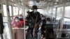 A policeman checks a passenger bus at a checkpoint on the second day of a stricter lockdown to prevent the spread of the coronavirus in the outskirts of Quezon City, Philippines, on March 30, 2021.