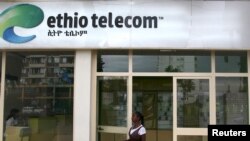 FILE - A woman walks past an Ethio Telecom office in Ethiopia's capital, Addis Ababa, Nov. 9, 2015. 