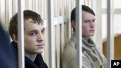 Leader of the Young Front opposition group Dmitry Dashkevich (l) and opposition activist Eduard Lobov during a court hearing in Minsk, March 24 2011