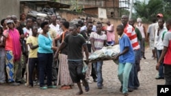 Men carry away a dead body in the Nyakabiga neighborhood of Bujumbura, Burundi, Dec. 12, 2015. 