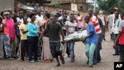 Men carry away a dead body in the Nyakabiga neighborhood of Bujumbura, Burundi, Dec. 12, 2015. 