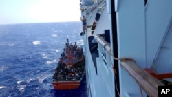 Apparent refugees are seen on a small boat after being rescued off the Cyprus's main Limassol port, Cyprus, Sept. 25, 2014. 