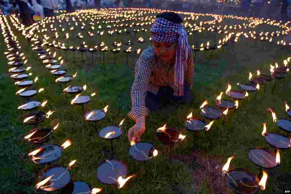 A boy lights candles during the Visak Bochea Buddhist celebration at a pagoda in Phnom Penh, Cambodia, May 18, 2019. Buddhists commemorate the birth of Buddha, his attaining enlightenment and death on the day of the full moon, which falls on May 18 this year.