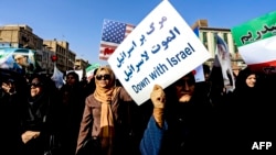 Pro-government demonstrators hold banners during a march in Iran's southwestern city of Ahvaz on Jan. 3, 2018, as tens of thousands gathered across Iran in a massive show of strength for the Islamic rulers after days of deadly unrest.