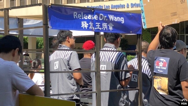 民主活动人士六月二十七日星期六在中国驻洛杉矶总领馆前表演行为艺术，呼吁释放王炳章和其他政治犯。王炳章是2002年六月二十七日被中国政府绑架的。