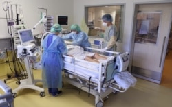 FILE - Medical staff take care of a COVID-19 patient in the COVID-19 intensive care unit of the community hospital in Magdeburg, Germany, Apr. 28, 2021.