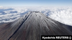 Puncak Gunung Fuji tertutup salju dalam foto yang diambil oleh Kyodo, Jepang, 6 November 2024. (Foto: Kyodo via REUTERS)