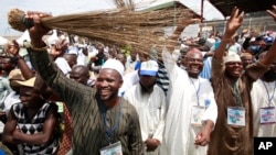 Members of All Progressives Congress party waves brooms the symbol of the party as former military ruler and Presidential aspirant Muhammadu Buhari, delivered a speech during the party convention in Lagos, April 18, 2013.