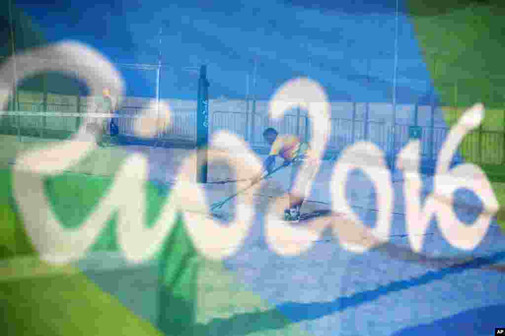 A workers rakes a court after a practice session at the beach volleyball venue on Copacabana Beach ahead of the upcoming 2016 Summer Olympics in Rio de Janeiro, Brazil, Tuesday, Aug. 2, 2016. (AP Photo/David Goldman)
