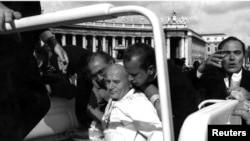 FILE - Pope John Paul II lies bleeding in his open car moments after he was shot by Turkish gunman Mehmet Ali Agca in 1981.