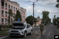 FILE - A Ukrainian soldier walks past a city hall in Sudzha, in the Kursk region of Russia, on Aug. 16, 2024. This image was approved by the Ukrainian Defense Ministry before publication.