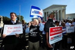 FILE - Protesters join others in a rally for fair elections, outside the U.S. Supreme Court in Washington, Oct. 3, 2017.