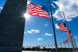 American flags around the Washington Monument are lowered to half-staff in honor of Colin Powell, former Joint Chiefs chairman and secretary of state, Oct. 18, 2021.