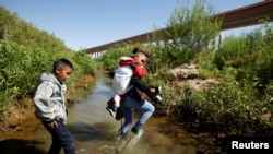 Migrants from Guatemala are seen on the banks of the Rio Bravo river as they cross to the U.S. to request asylum in El Paso, Texas, as seen from Ciudad Juarez, Mexico June 6, 2019. REUTERS/Jose Luis Gonzalez