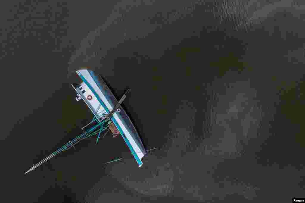 Fuel leaks from a capsized boat along Bayou Lafourche in the aftermath of Hurricane Ida in Galliano, Louisiana, Aug. 31, 2021.