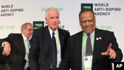 Newly-appointed World Anti-Doping Agency (WADA) president Craig Reedie, center, with his vice-president Makhenkesi Stofile, right, and the outgoing president John Fahey, in Johannesburg, Nov. 15, 2013.