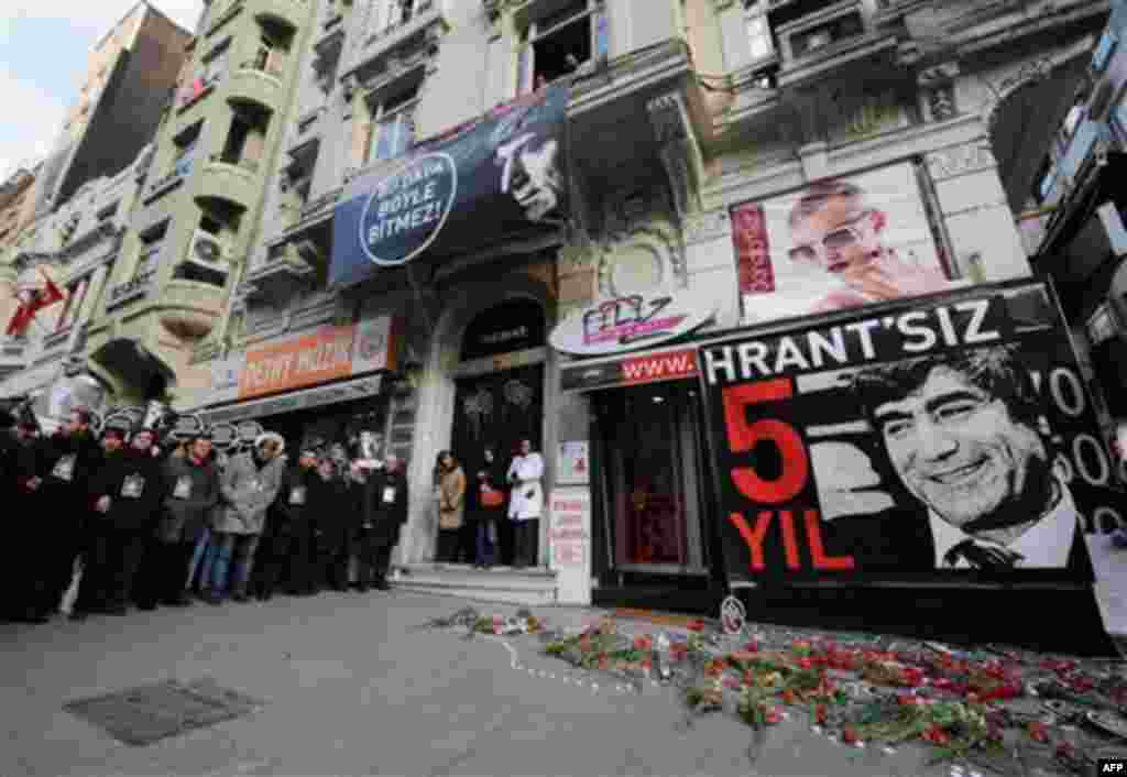Friends stand outside his office as tens of thousands of protesters march to mark the fifth anniversary of Turkish-Armenian journalist Hrant Dink's murder in Istanbul, Turkey, Thursday, Jan. 19, 2012, as outrage continues to grow over a trial that failed