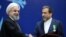 Iranian President Hassan Rouhani, left, shakes hand with Iran's deputy Foreign Minister and senior nuclear negotiator Abbas Araghchi after awarding him a medal of honor in a ceremony in Tehran, Iran, Feb. 8, 2016. 