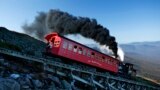 A vintage coal-fired steam engine pushes a passenger car up the Cog Railway on a 3.8-mile journey to the summit of 6,288-foot Mount Washington in New Hampshire.