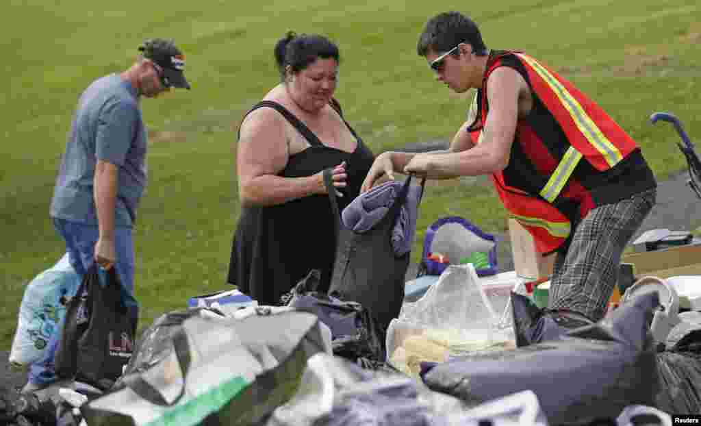 Một tình nguyện viên phát đồ cứu trợ cho một phụ nữ phải sơ tán khỏi nhà sau vụ nổ xe lửa ở Lac Mégantic, Québec, Canada, 7 tháng 7, 2013.