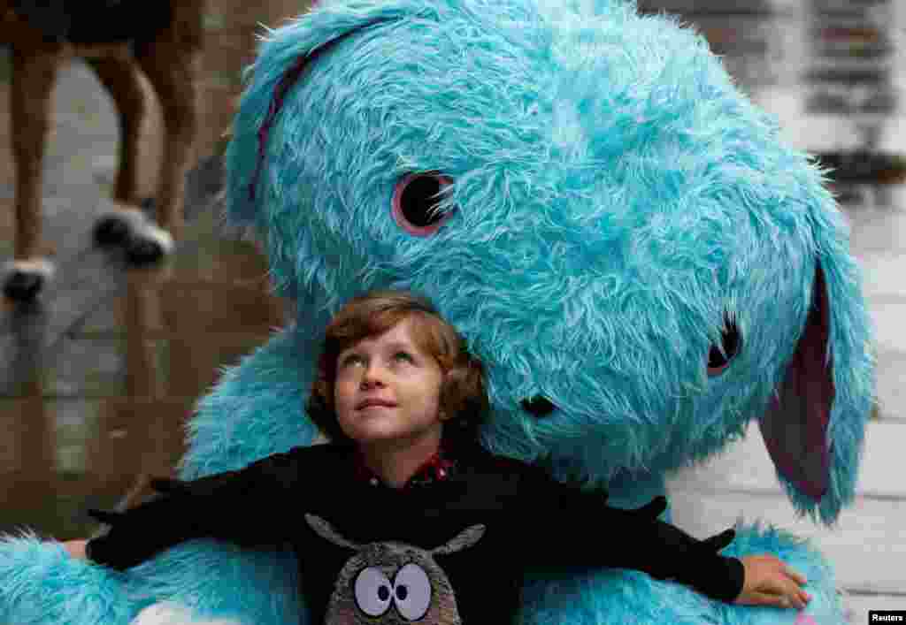 Winston Bartlett, 9, poses for a photograph with a giant Scruff-a-luvs toy at Hamleys store, ahead of announcing their top-ten Christmas toys, in London, Britain.