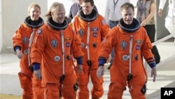 The crew of space shuttle Atlantis, from left, mission specialist Sandy Magnus, pilot Doug Hurley, mission specialist Rex Walhiem and commander Chris Ferguson, leave the Operations and Checkout Building on their way to board the shuttle for their final d