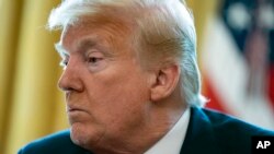 President Donald Trump listens during an Easter blessing event with Bishop Harry Jackson, in the Oval Office of the White House, April 10, 2020, in Washington.