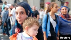 Dayikeke penaber û zarokê wê li Budepeşt a Hungarya li bendê çûyîna Almanya yan Avusturya ne