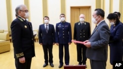 Russian Ambassador Alexander Matsegora, left, and North Korean Foreign Minister Ri Son-gwon, foreground right, attend a ceremony of awarding North Korean leader Kim Jong-un with Russia's 75th anniversary Victory medal. 