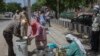 Para relawan mendistribusikan makanan kepada para keluarga miskin di tengah karantina wilayah di yang diberlakukan di Dwarka, New Delhi, India, pada 12 April 2020. (Foto: AP)
