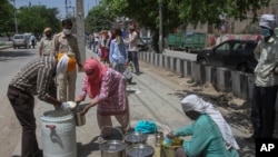 Volunteers distribute food to the poor during a lockdown to prevent the spread of the new coronavirus, in the Dwarka area of New Delhi, India, April 12, 2020. 