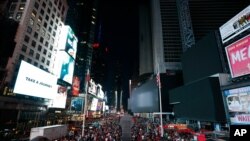 Screens in Times Square are black during a power outage, July 13, 2019, in New York. The outage knocked out Times Square's electronic screens, darkened marquees in the theater district and left businesses dark, elevators stuck and subway cars stalled.