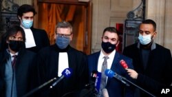Alek Skarlatos, center right, Anthony Sadler, right, Mark Moogalian, left, and their lawyer Thibault de Montbrial, center left, speak outside the Paris courthouse, Nov. 20, 2020. They've gathered for the trial of suspects in train attack attempt.