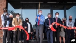 New York Mayor Bill de Blasio, center, alongside Matthew Putman, co-founder of Nanotronics, center right, participate in ribbon-cutting ceremony to mark the opening of a Nanotronics manufacturing center at the Brooklyn Navy Yard, New York, April 28, 2021.