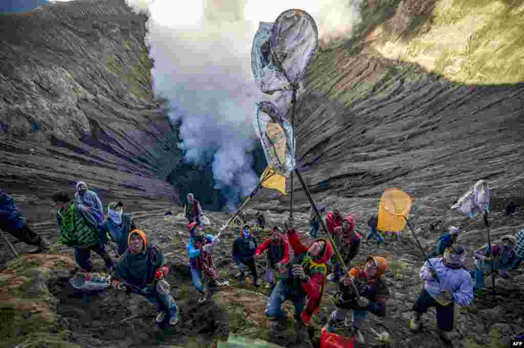People prepare to catch offerings thrown by Tengger tribe people into the crater of Bromo volcano to in Probolinggo, East Java province, Indonesia, June 30, 2018, as part of Yadnya Kasada festival which falls on the 14th day of the Kasada month based on the traditional Hindu lunar calendar.