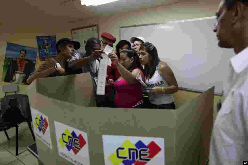 Election monitors look at a count of ballots as a polling station is being closed in Caracas.