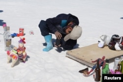 Piter Condori, 11, takes pictures of tourists behind toy figures to earn money for his family, at the Uyuni Salt Flat in Bolivia March 27, 2022. (REUTERS/Claudia Morales)