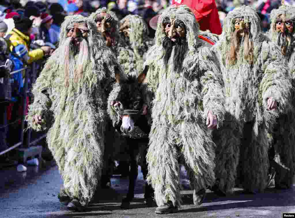 Pria berkostum dan bertopeng tradisional ikut serta dalam festival Schleicherlaufen di kota Australia barat, Telfs.