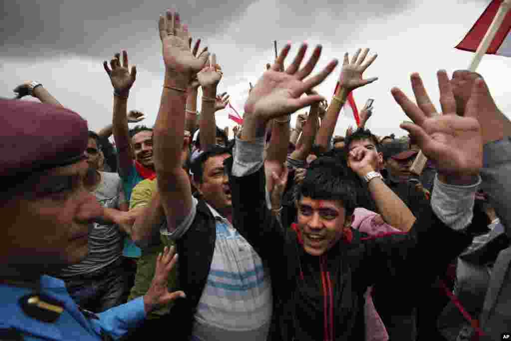 Nepalese cheer to celebrate the adoption of the country's new constitution in Kathmandu. Nepal formally adopted a much anticipated and long-delayed constitution that took more than seven years to complete following a decade of political infighting.