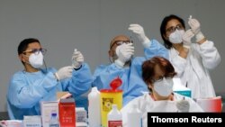 Health workers prepare doses of the Pfizer-BioNTech COVID-19 vaccine at a coronavirus disease (COVID-19) vaccination center in Naples, Italy, Jan. 8, 2021.