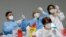 Health workers prepare doses of the Pfizer-BioNTech COVID-19 vaccine at a coronavirus disease (COVID-19) vaccination center in Naples, Italy, Jan. 8, 2021.