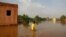 A boy wades through a flooded street in the area of al-Qamayir in the capital's twin city of Omdurman, Sudan, Aug. 26, 2020. 
