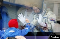 British astronaut Tim Peake, a member of the main crew of the International Space Station, waves to his children from a bus prior the launch of Soyuz TMA-19M space ship, at the Russian leased Baikonur cosmodrome, Kazakhstan, Dec. 15, 2015.