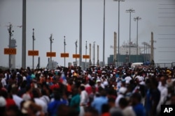 Thousands of spectators watch as the Neopanamax cargo ship, Cosco Shipping Panama, prepares to cross the new new Agua Clara locks, part of the Panama Canal expansion project, near the port city of Colon, Panama, June 26, 2016.