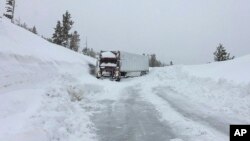 A big rig lacking tire chains slid into a snowbank blocking State Route 88 in Amador County near Tragedy Springs, Calif., Feb. 14, 2019. The snow was so deep in some areas, plows couldn't go out.