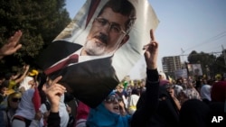 An Egyptian woman holds a portrait of ousted Egyptian President Mohamed Morsi during a protest in Nasr City in Cairo, Nov. 1, 2013.