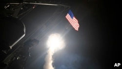 FILE - The guided-missile destroyer USS Porter launches a tomahawk land attack missile from the Mediterranean Sea, April 7, 2017.