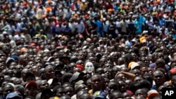 Supporters of opposition leader Raila Odinga, one wearing a mask, attend a mock "swearing-in" ceremony at Uhuru Park in downtown Nairobi, Kenya, Jan. 30, 2018. 